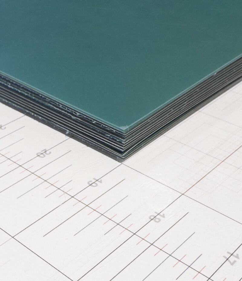 Stack of Torelief WS95HK2 steel-backed photopolymer photogravure plates, green polymer surface, on a cutting mat