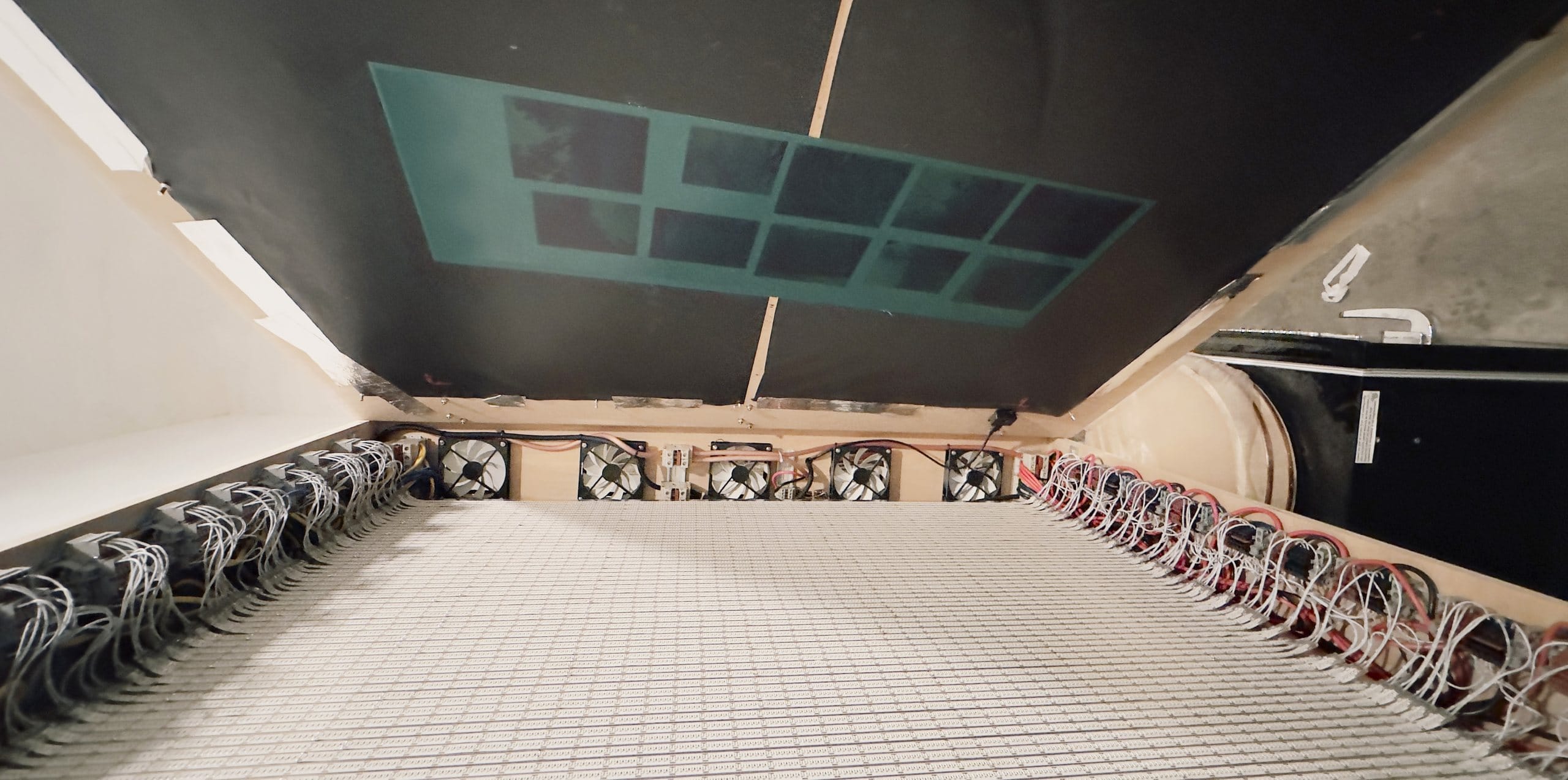 Intérieur d’une unité d’insolation UV DIY : rangées de rubans LED UV TRUE-365 365 nm avec ventilateurs de refroidissement et câblage, sous une plaque d’héliogravure