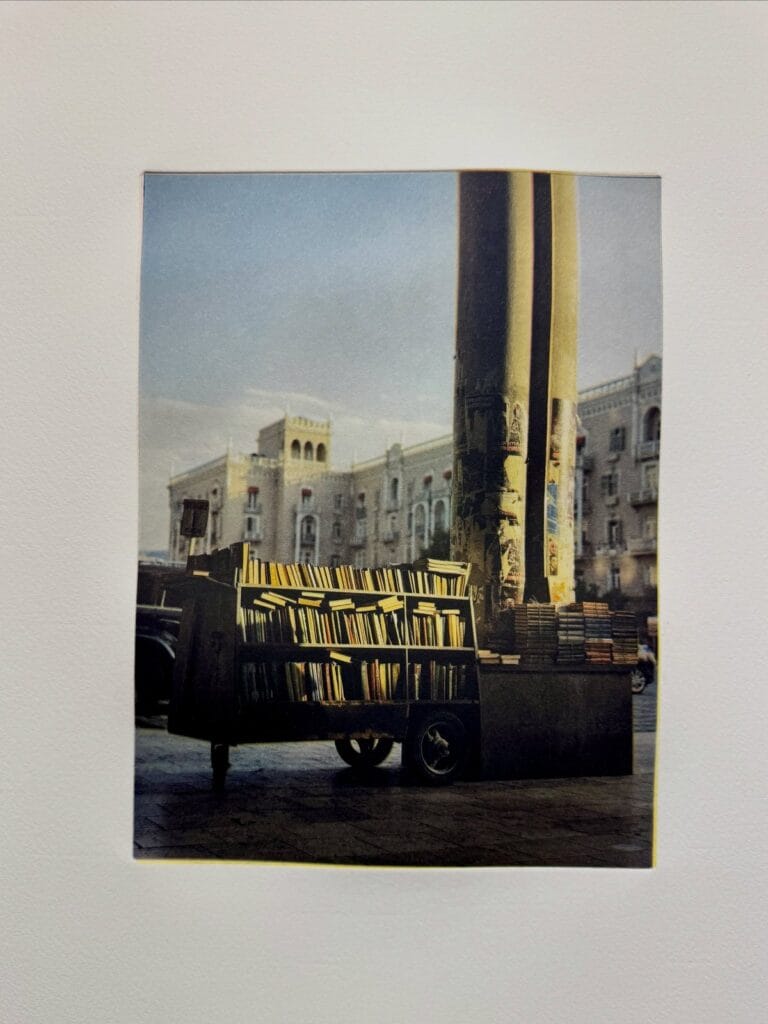 Color photogravure of a bookseller’s cart beside tall columns, printed at a Prints on Paper Studio workshop