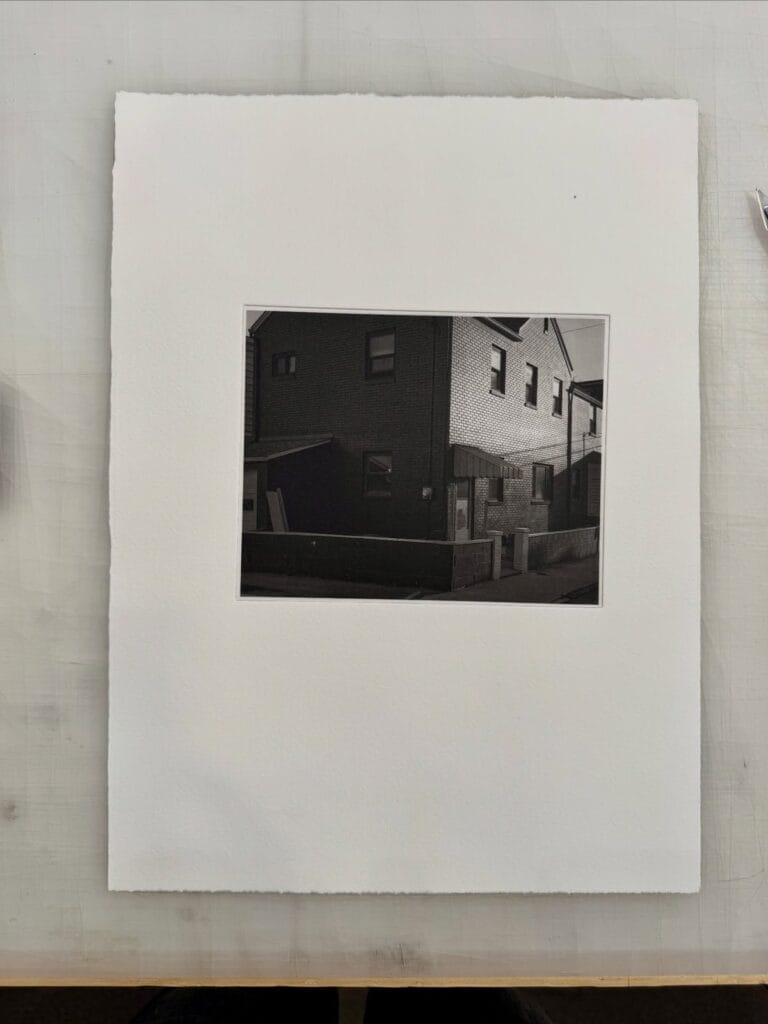 Photogravure print of a brick house, made during a calibration workshop at Prints on Paper Studio