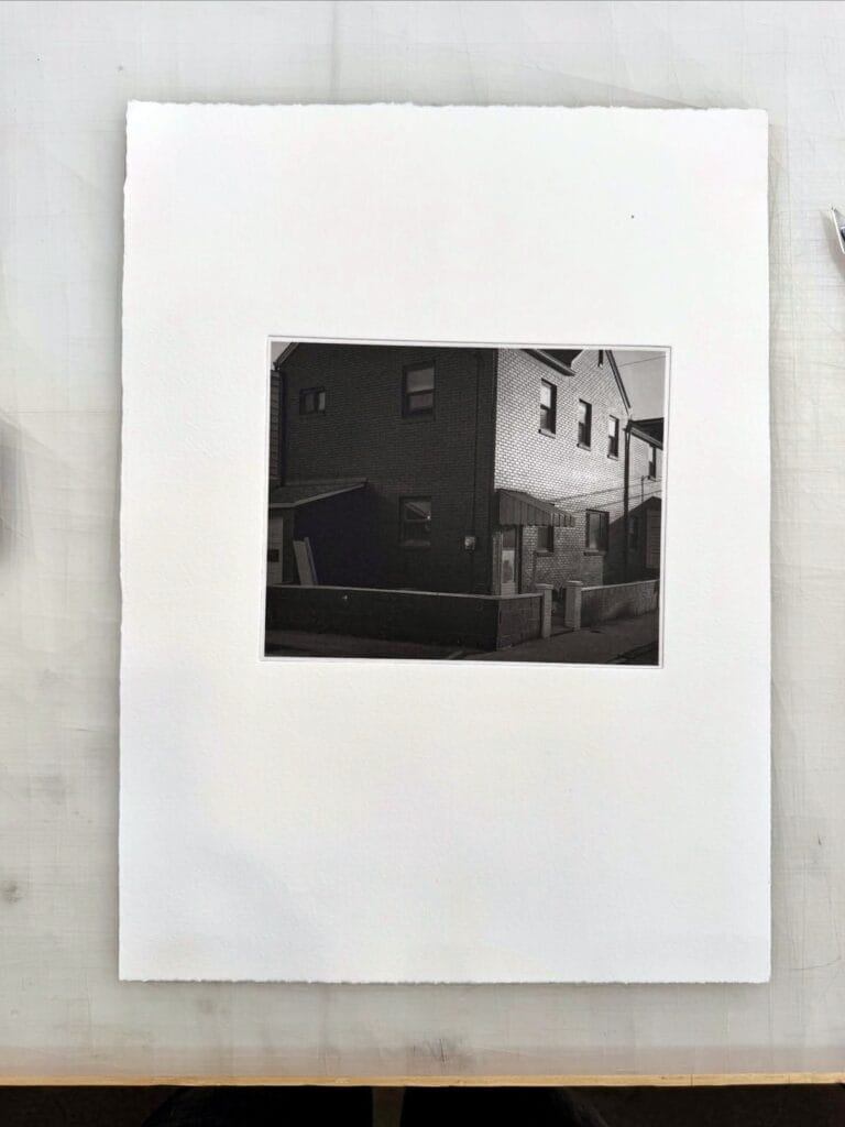 Photogravure print of a brick house, made during a calibration workshop at Prints on Paper Studio